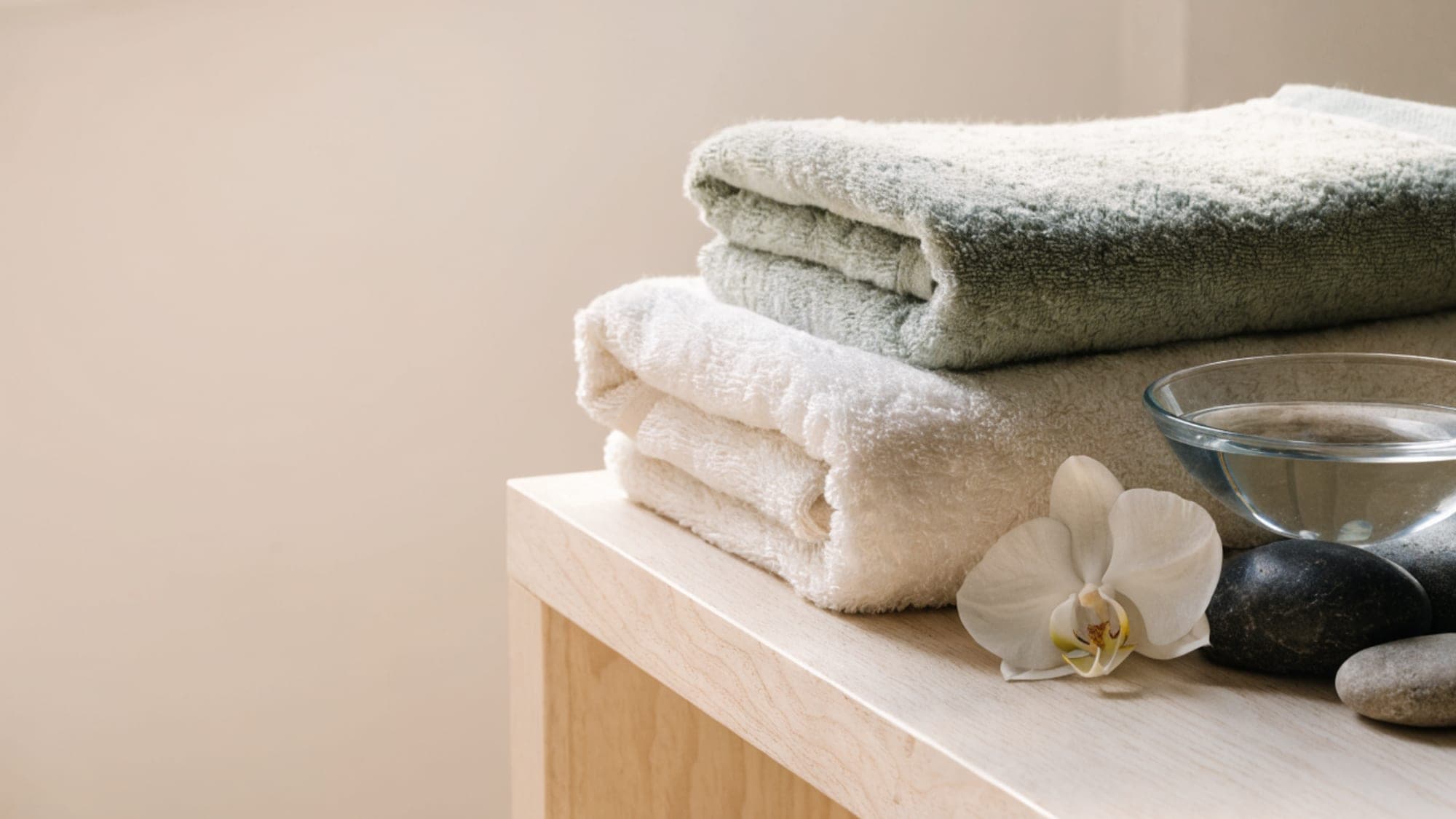 Folded spa towels, orchid and stones
